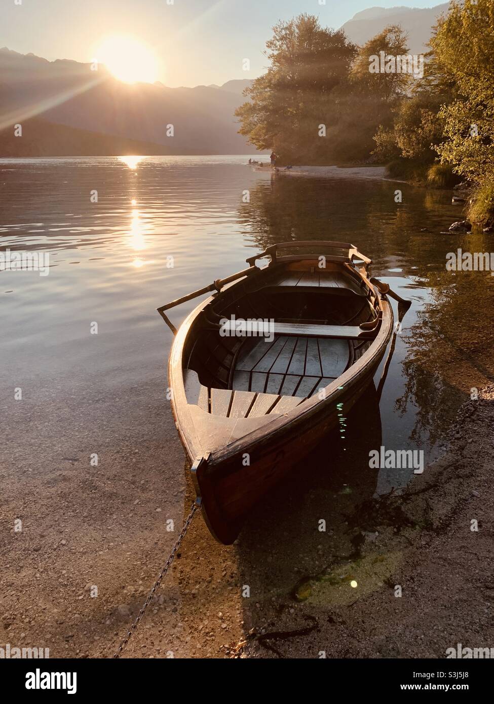 Row boat at sunset on lake bohinj Stock Photo