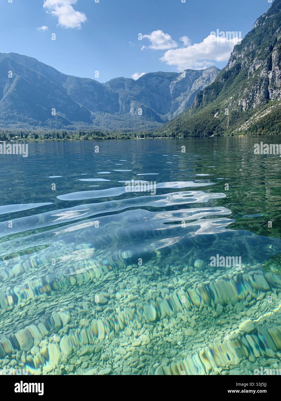 View of clear water and mountains of lake bohinj Stock Photo