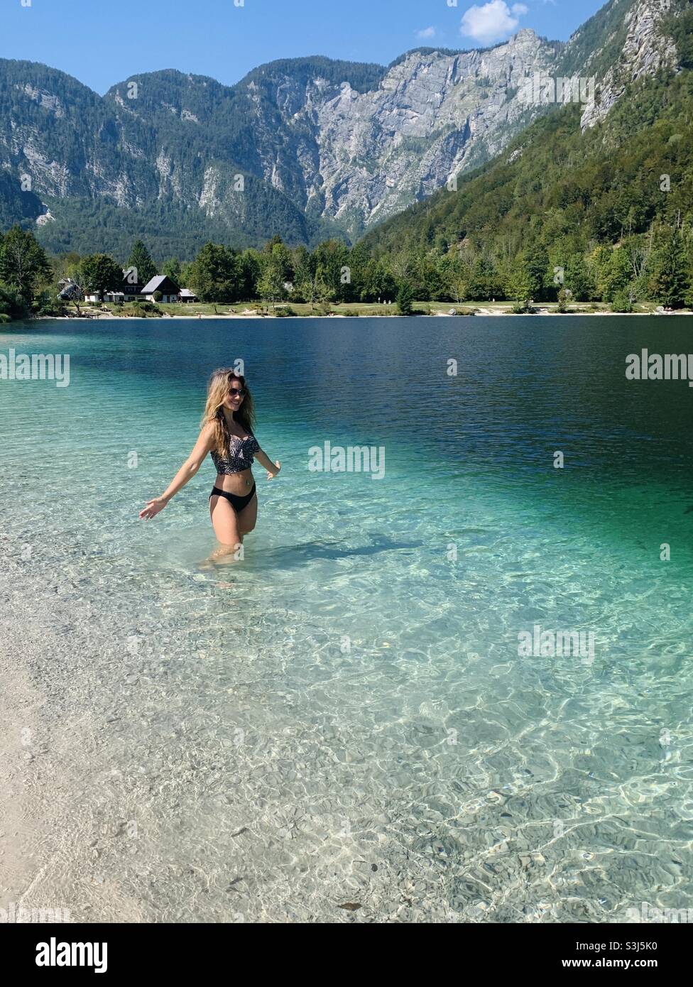 Woman wading in water at lake bohinj Slovenia Stock Photo