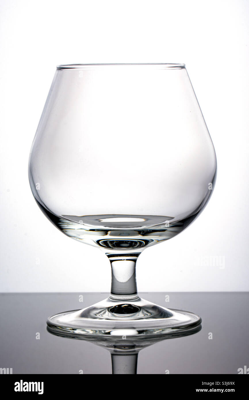 An empty glass is isolated on a white background, a glass for cognac, a snifter. Stock Photo