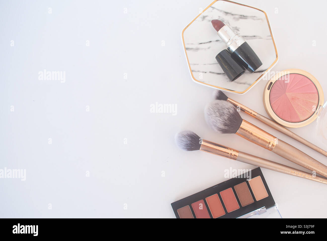 Makeup brushes, lipstick, powder and eye shadows in a white background Stock Photo