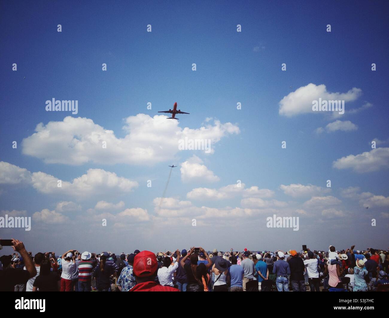 An aeroplane flying over the crowd of spectators at an air show in South Africa - Smartphone Captured Stock Image