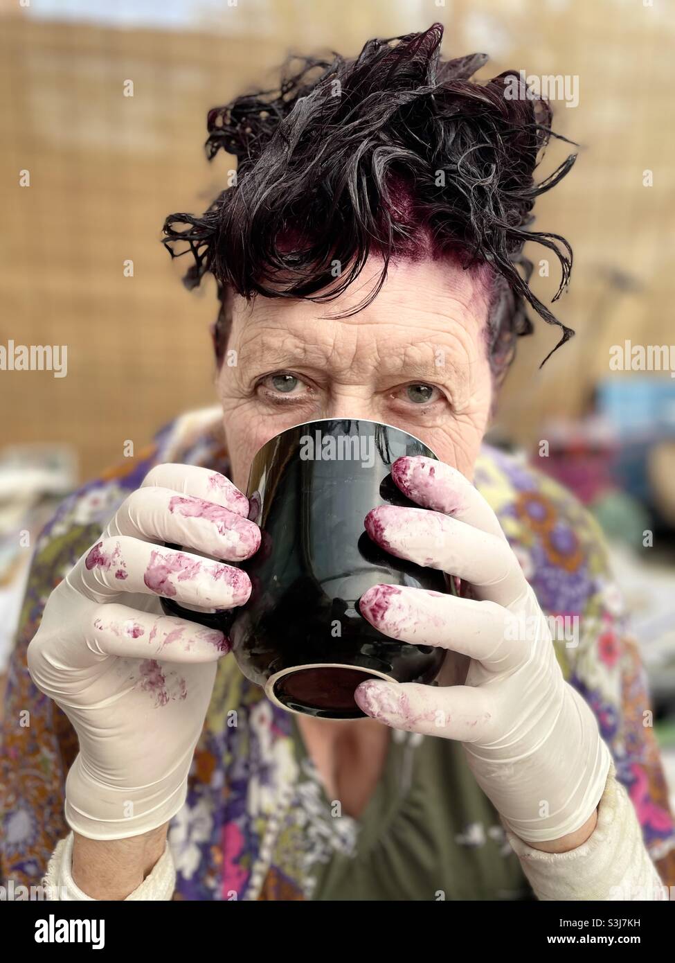 Woman having a coffee while her hair colour develops - Smartphone Captured Stock Image