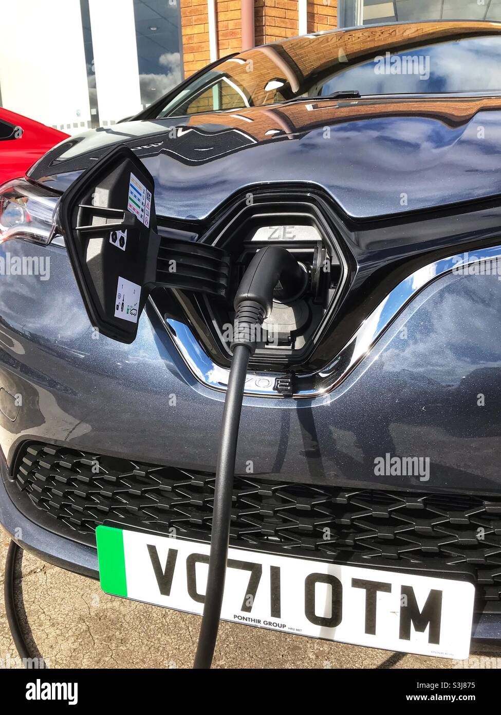 Brand new 71 registration Renault Zoe electric car being charged on a dealers forecourt September 2021 - Smartphone Captured Stock Image