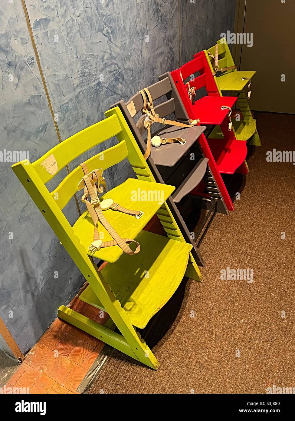 Colorful children high chairs lined up near a restaurant dining room, 2021, USA - Smartphone Captured Stock Image
