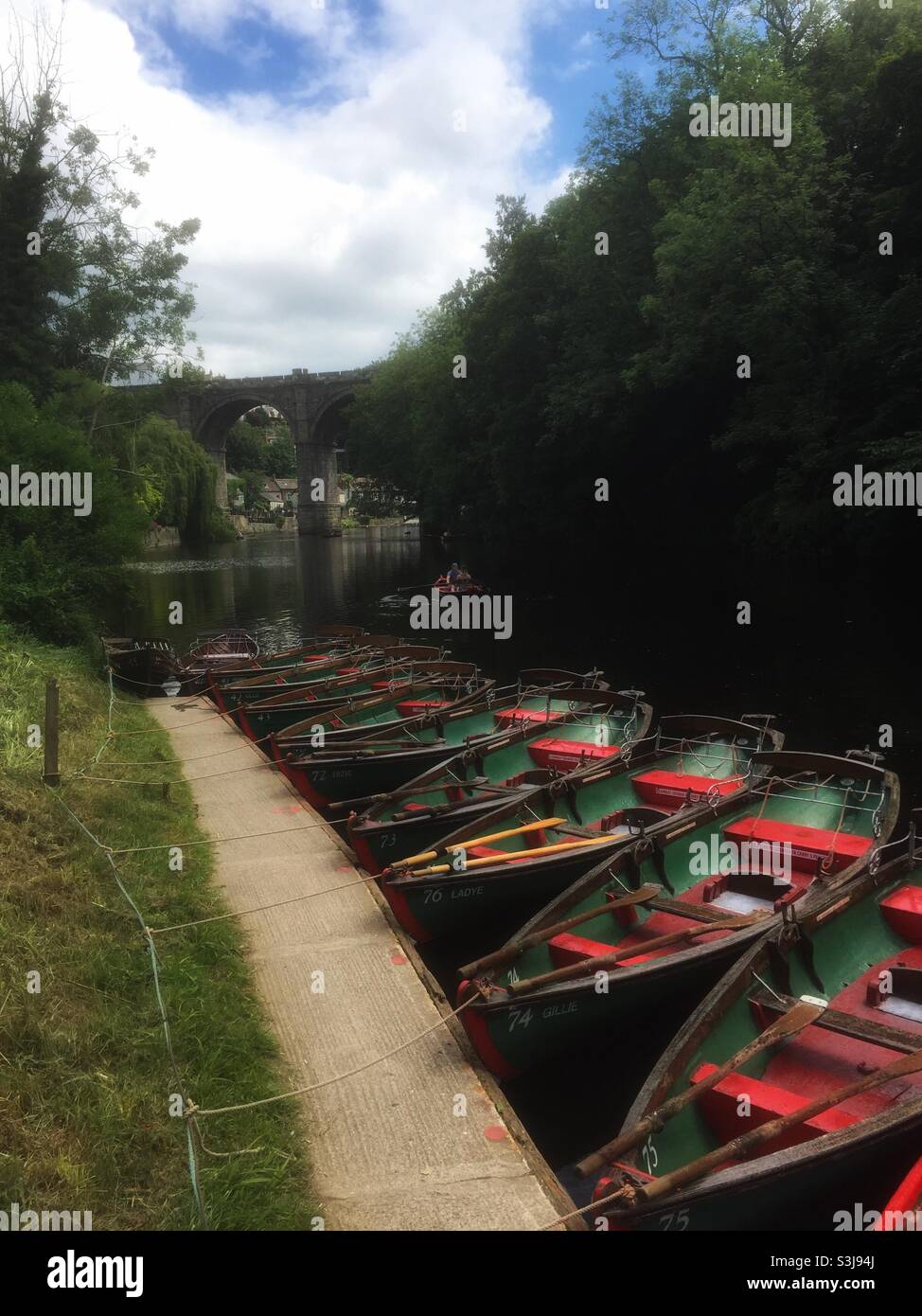 Rowing boats moored in front of the railway viaduct across the River Nidd at Knaresborough, North Yorkshire, UK. - Smartphone Captured Stock Image