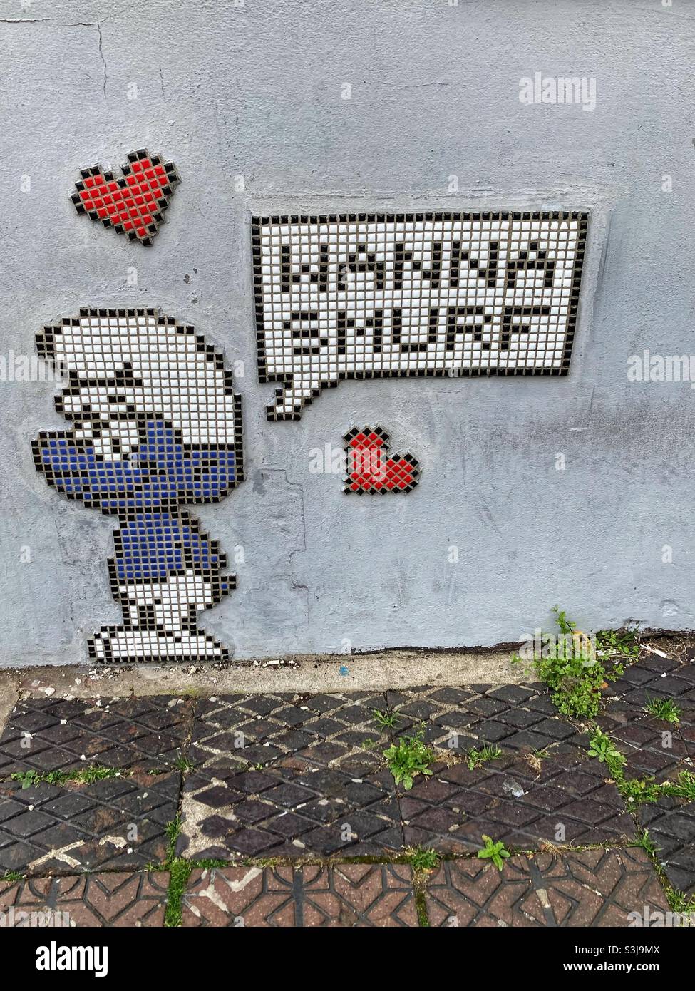 Wanna smurf, mosaic graffiti, North Street, Bristol, England- blue smurf - red hearts - Wall Street art Stock Photo