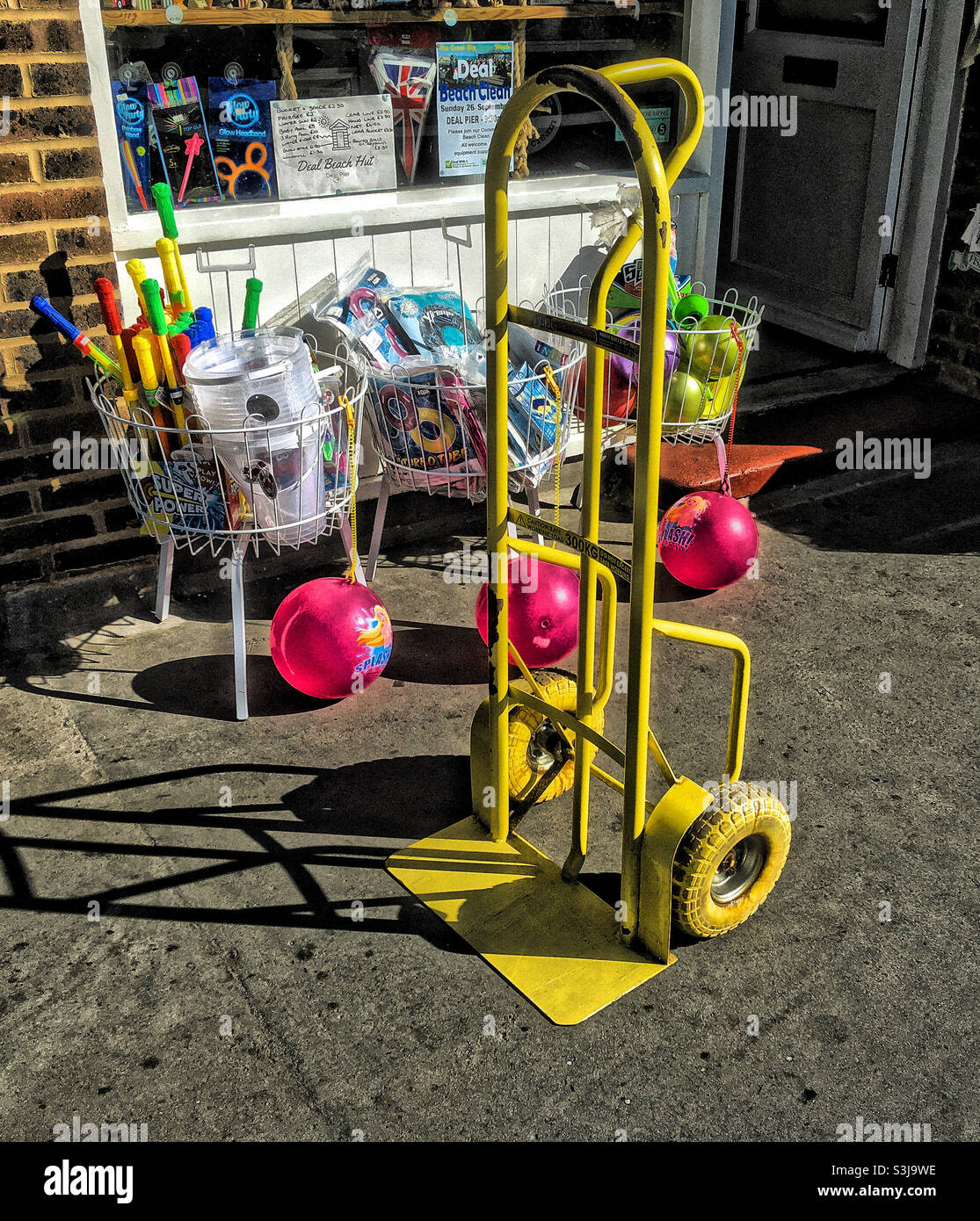 A Yellow Sack Barrow in front of a Seaside Novelty Shop, at the entrance to Deal Pier - Smartphone Captured Stock Image