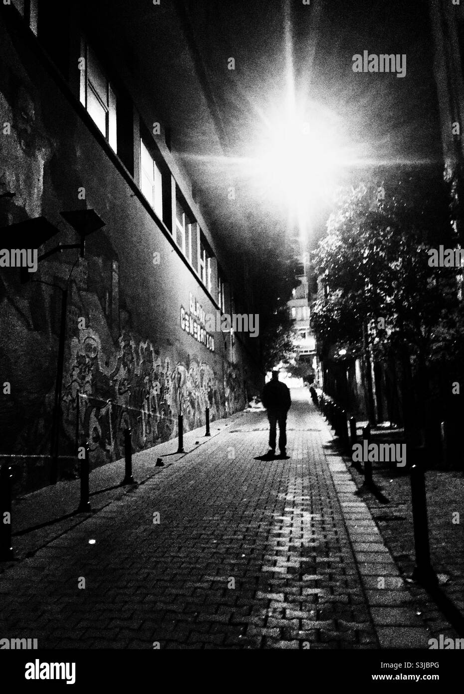 Man walking alone on a dark street at night - Smartphone Captured Stock Image