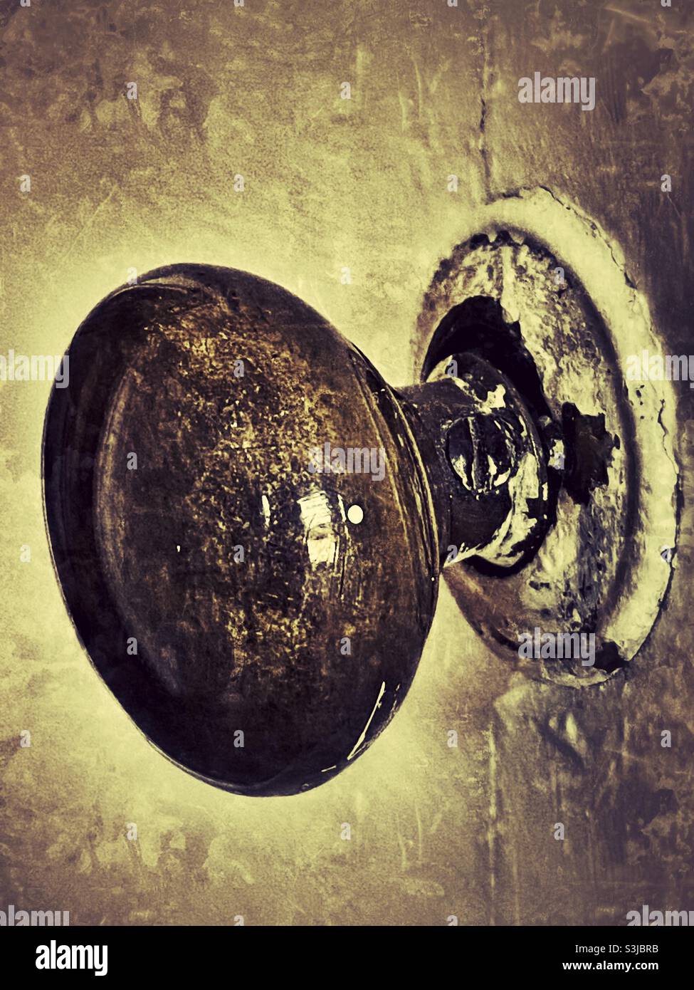Worn and damaged old looking victorian shiny brass door handle fixed to an ancient wooden door - Smartphone Captured Stock Image