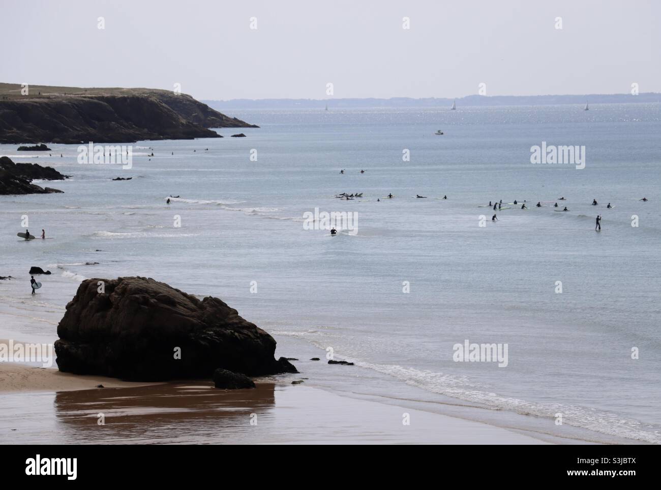 People enjoy the ocean for surfing at the wild coast of Quiberon in Brittany, France - Smartphone Captured Stock Image