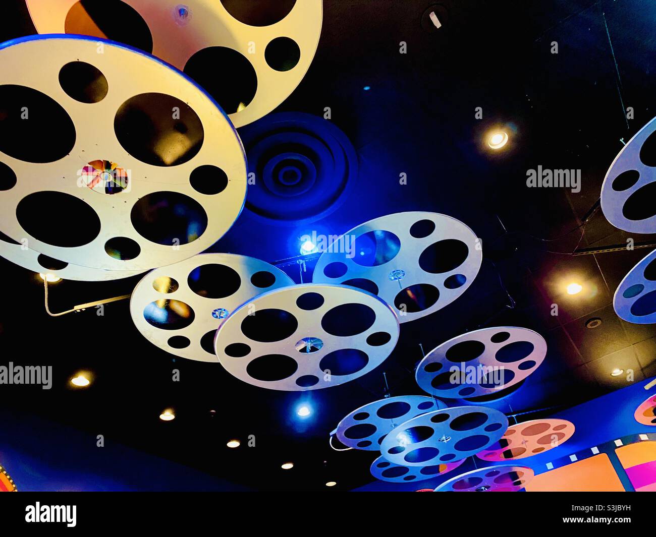 Old fashion movie film reels decorating the ceiling of a movie house theater. - Smartphone Captured Stock Image