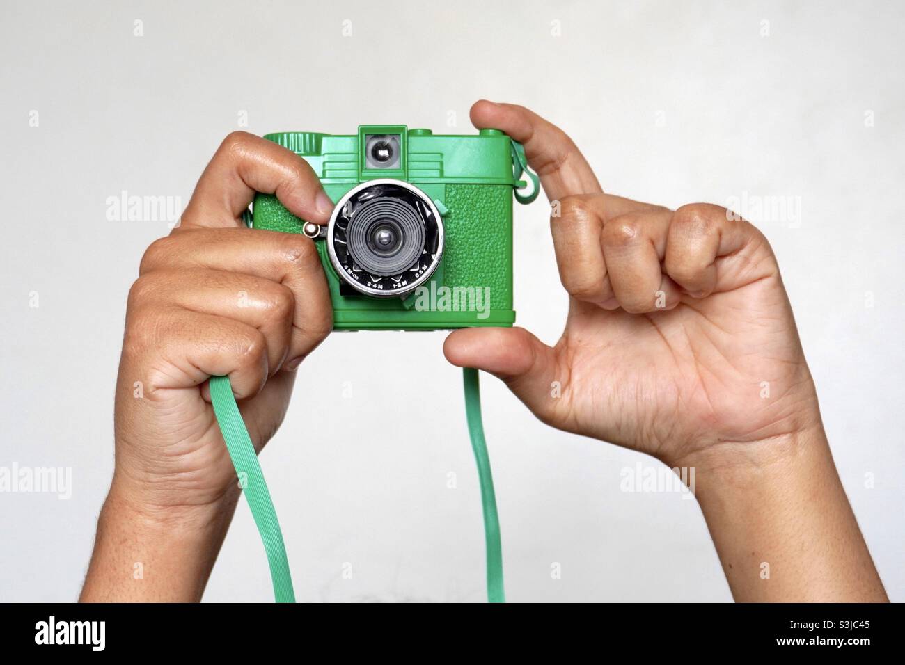 Photographer using a green analog camera Stock Photo