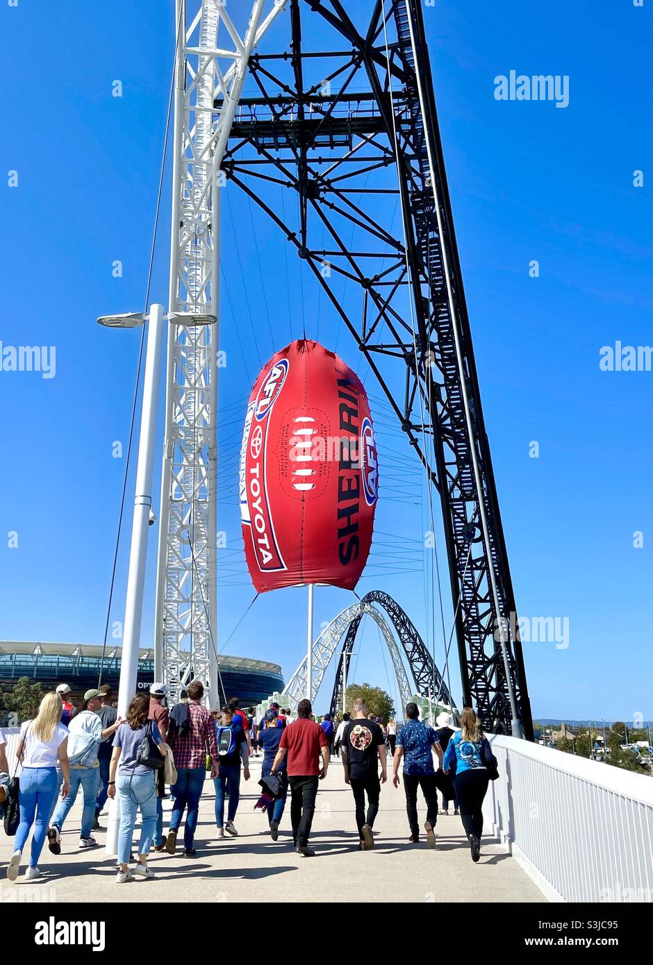 2021 AFL Grand Final at Optus Stadium, pregame crowd crossing Matagarup Bridge walking under Sherrin football balloon, Perth Western Australia. Stock Photo