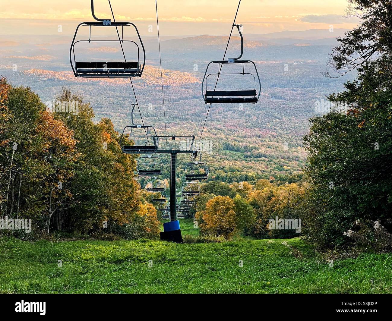 A ski lift at Bromley Mountain Resort in Winhall, Vermont sits dormant in the fall as the leaves start to change color and the state awaits the winter ski season. Stock Photo