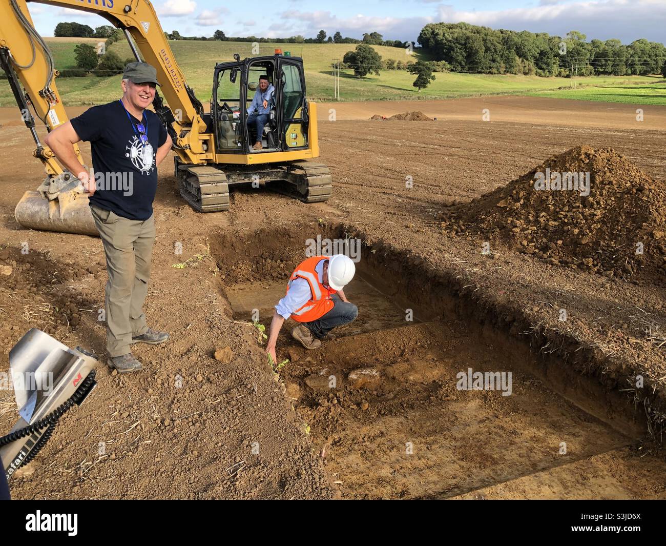 Scene from the second new Time Team programme which took place at Broughton Castle Roman Villa, with excavators at one of the trenches after it was opened by a mechanical excavator. - Smartphone Captured Stock Image
