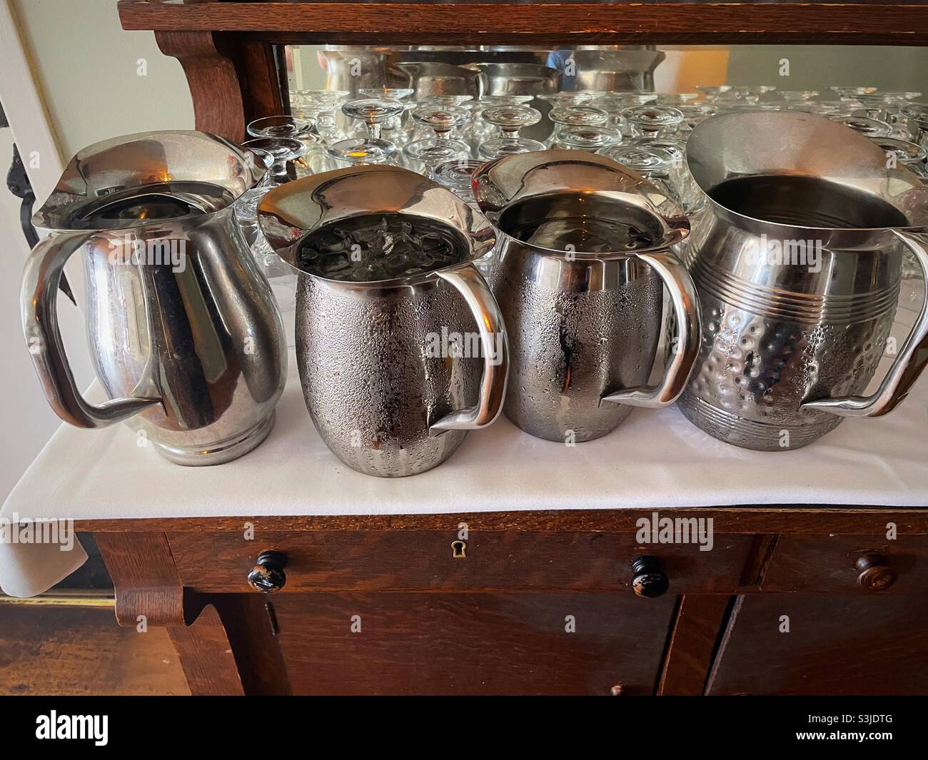 A row of metal water pitchers at a busboy station in a restaurant, United States Stock Photo