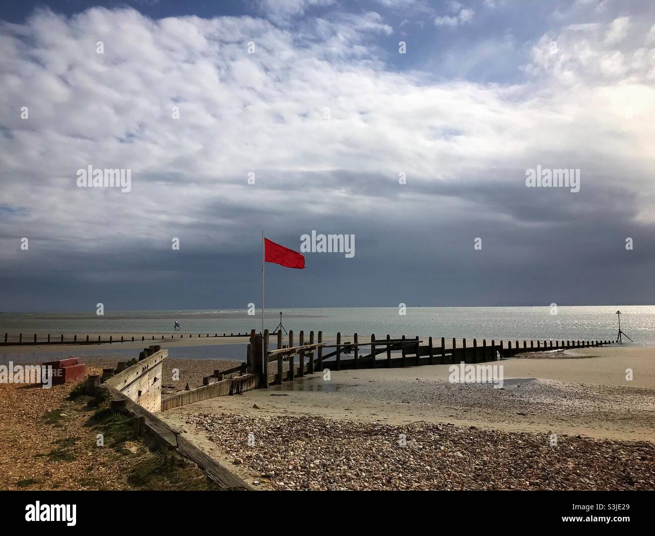 Red flag on the beach at West Wittering beach West Sussex UK - Smartphone Captured Stock Image