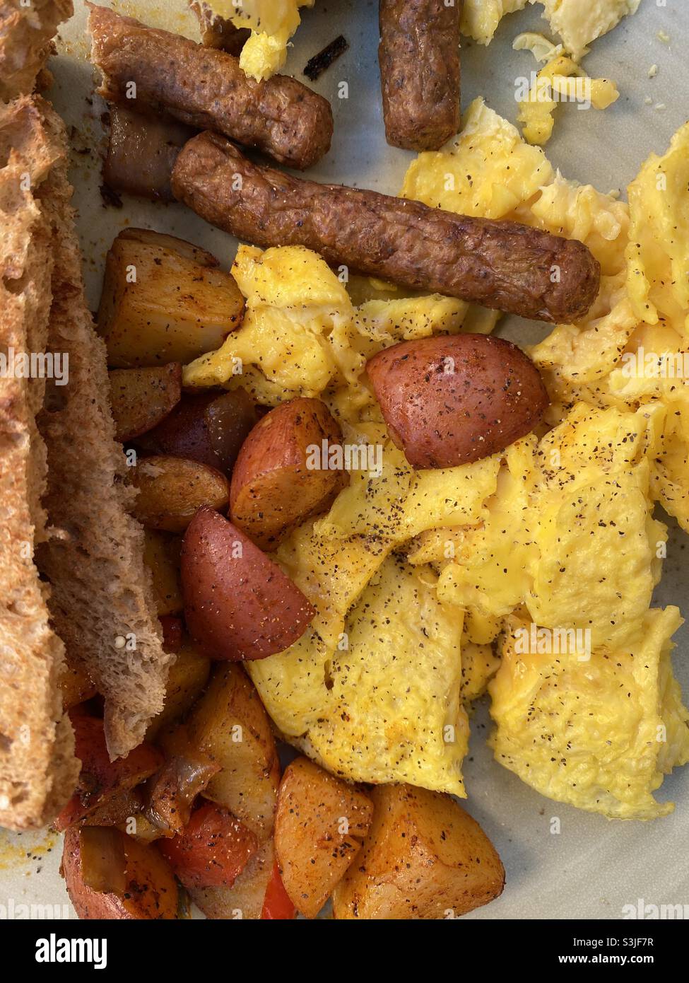 Typical American breakfast of scrambled eggs, home fries, sausage and toast. - Smartphone Captured Stock Image