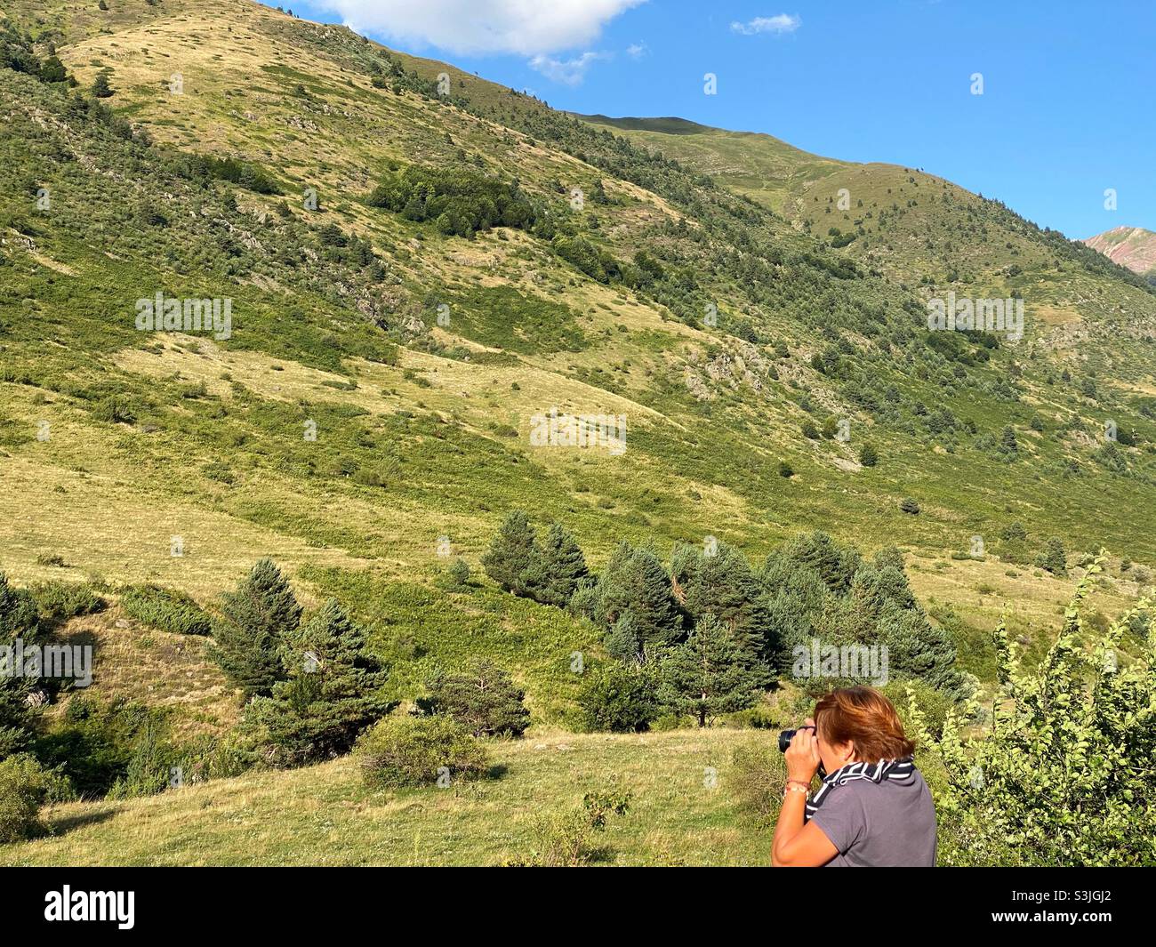Profile of a woman photographing a mountain Stock Photo