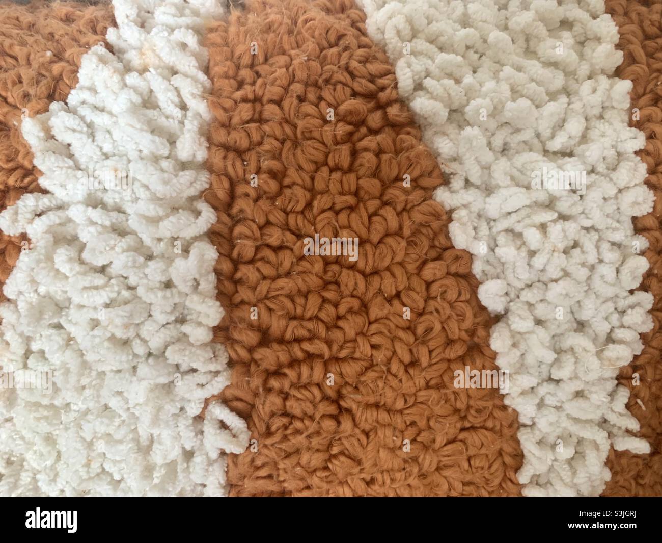 Textured shag carpet of orange and white 70’s fashion Stock Photo