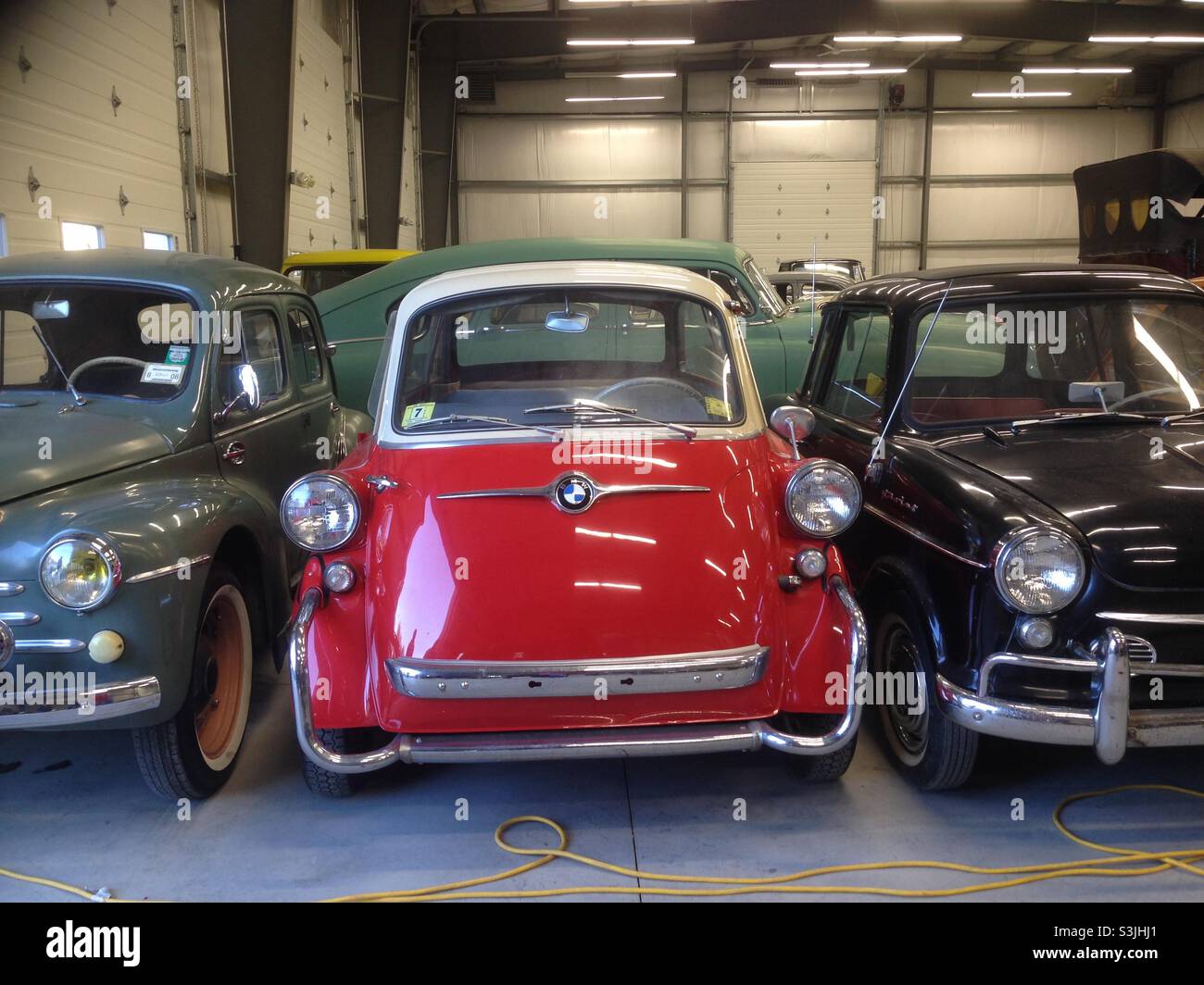 Vintage red BMW Isetta and other vintage cars in collection warehouse Stock Photo
