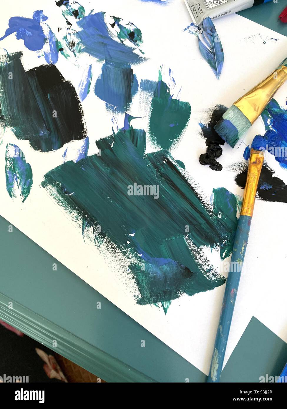 Hues of blue paint with creative artists paint brushes. Stock Photo
