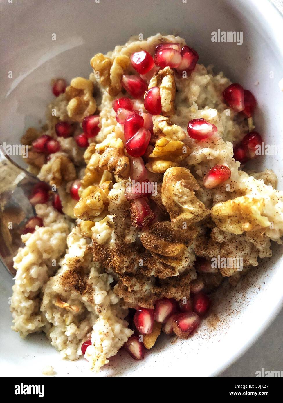 Oat meal porridge served with pomegranate and walnuts - Smartphone Captured Stock Image