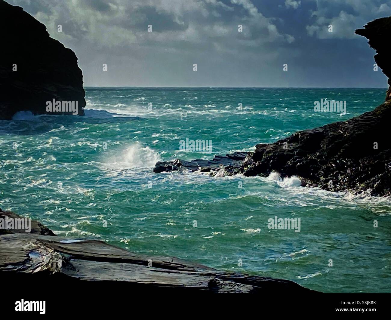 rough sea with waves splashing against deserted windswept seashore cliffs at Boscastle Cornwall UK - Smartphone Captured Stock Image