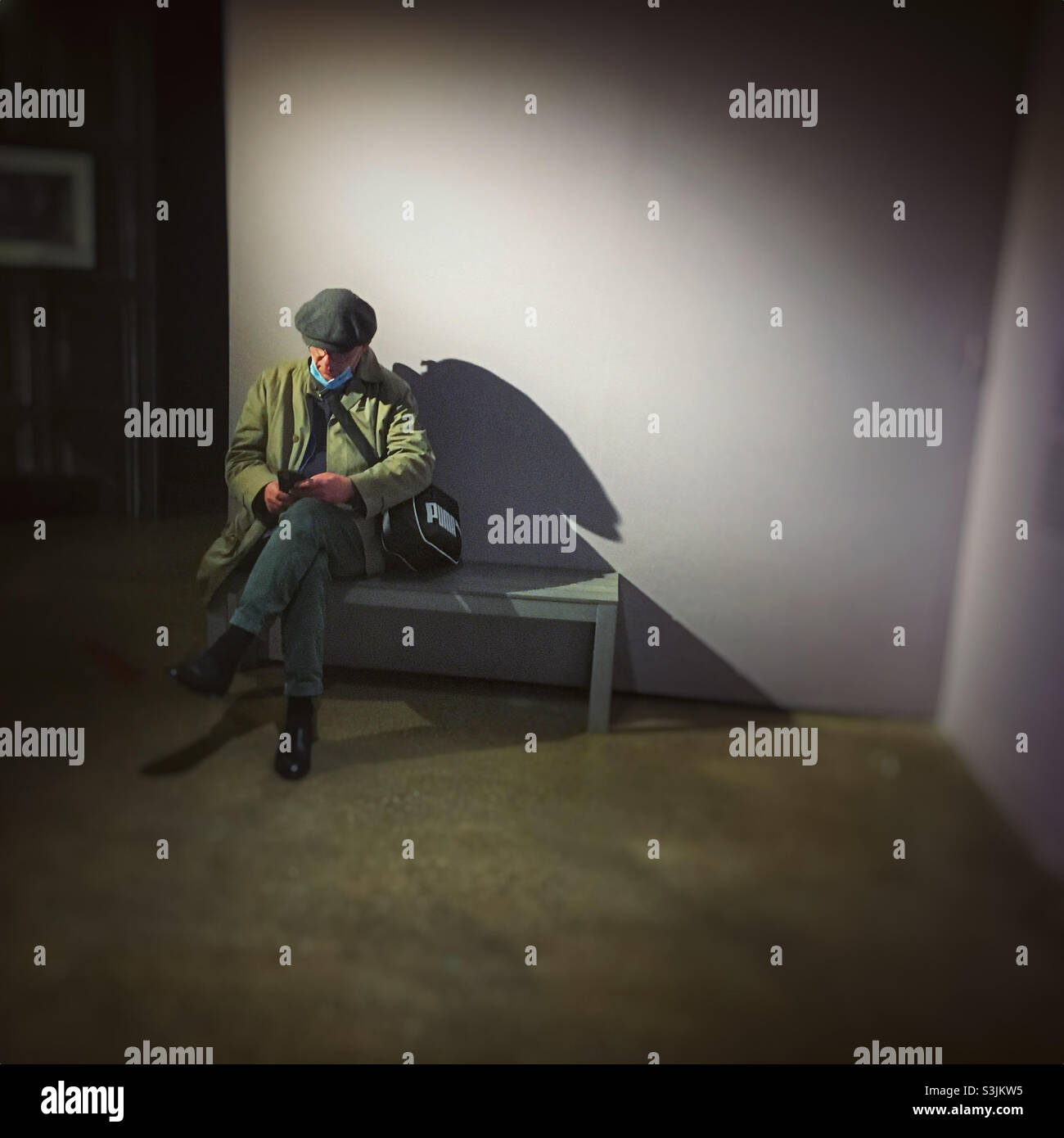 Man in museum using phone, mask off - Smartphone Captured Stock Image