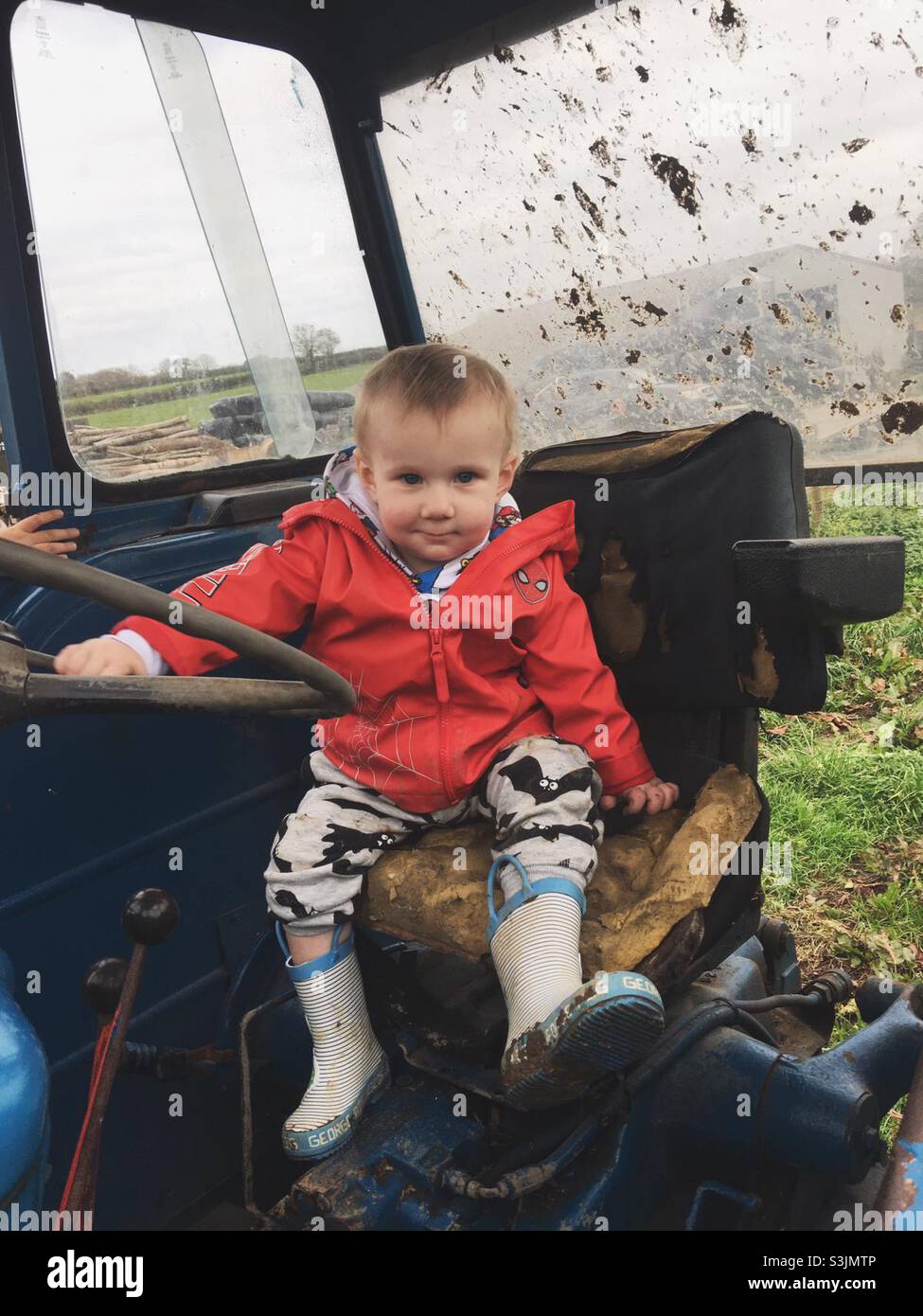 Toddler enjoying tractor ride Stock Photo - Alamy