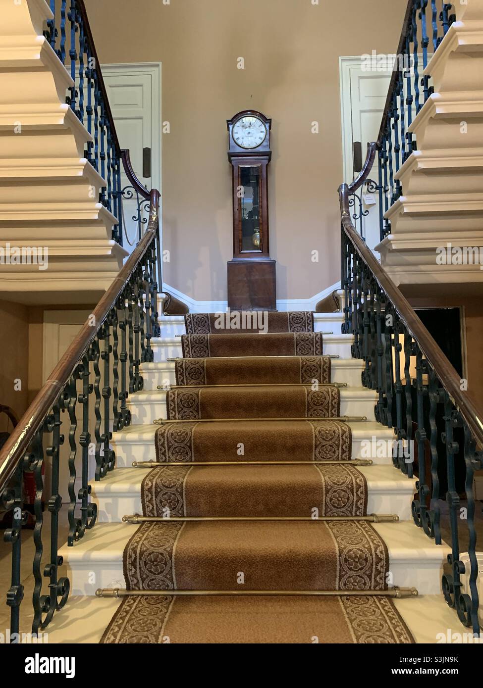 Staircase leading up towards grand clock - Smartphone Captured Stock Image