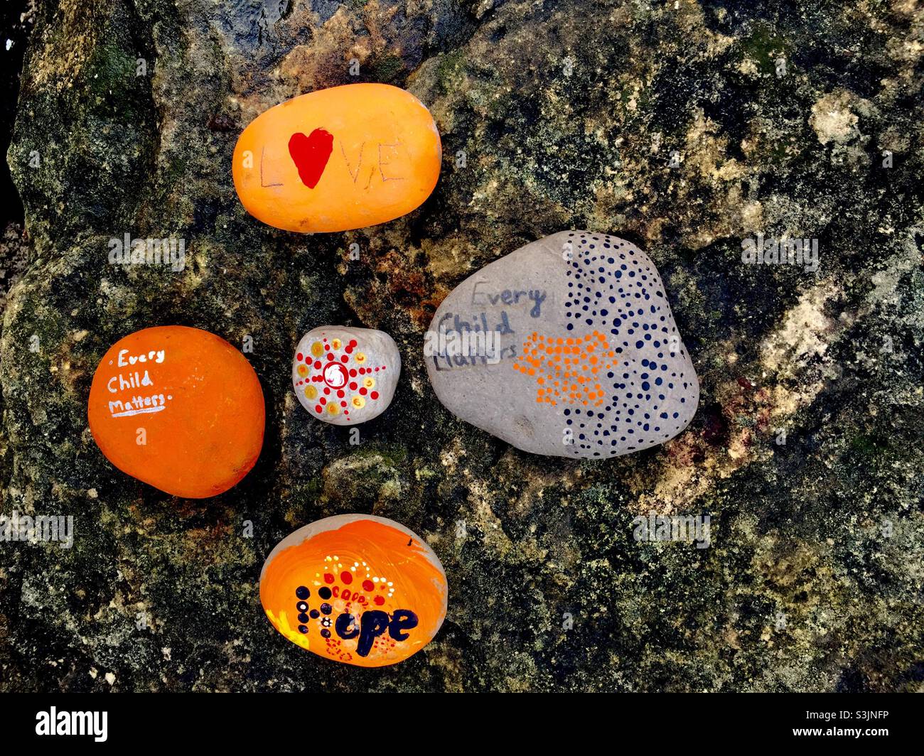 Message of hope and love painted on the stones: Every child matters. Simple, Colorful art left for public viewing in a park, Ontario, Canada. In recognition. - Smartphone Captured Stock Image