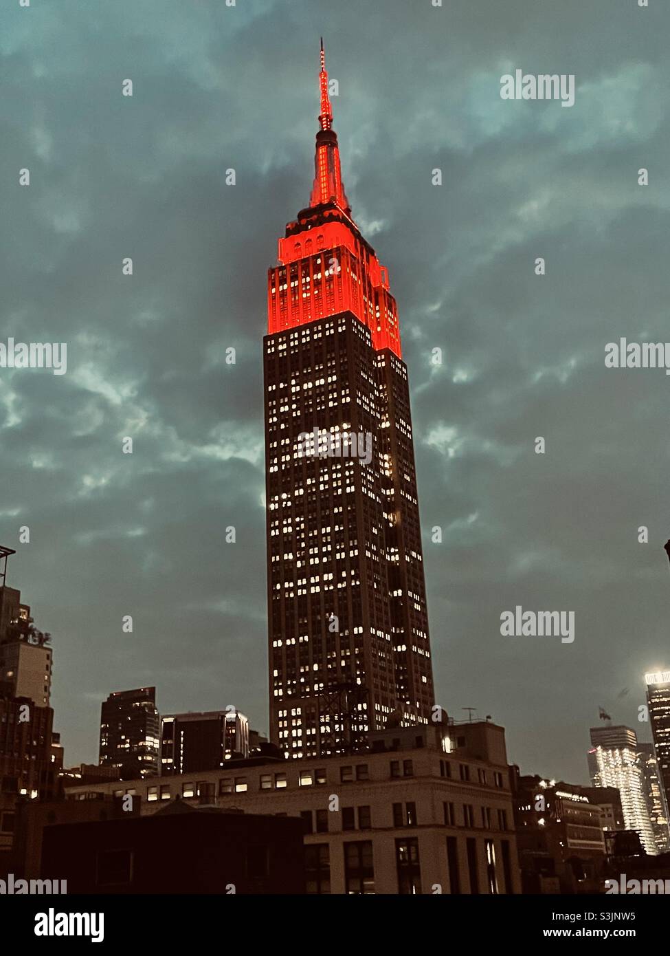 Bright red lights top of the Empire State building on a cloudy rainy evening - Smartphone Captured Stock Image