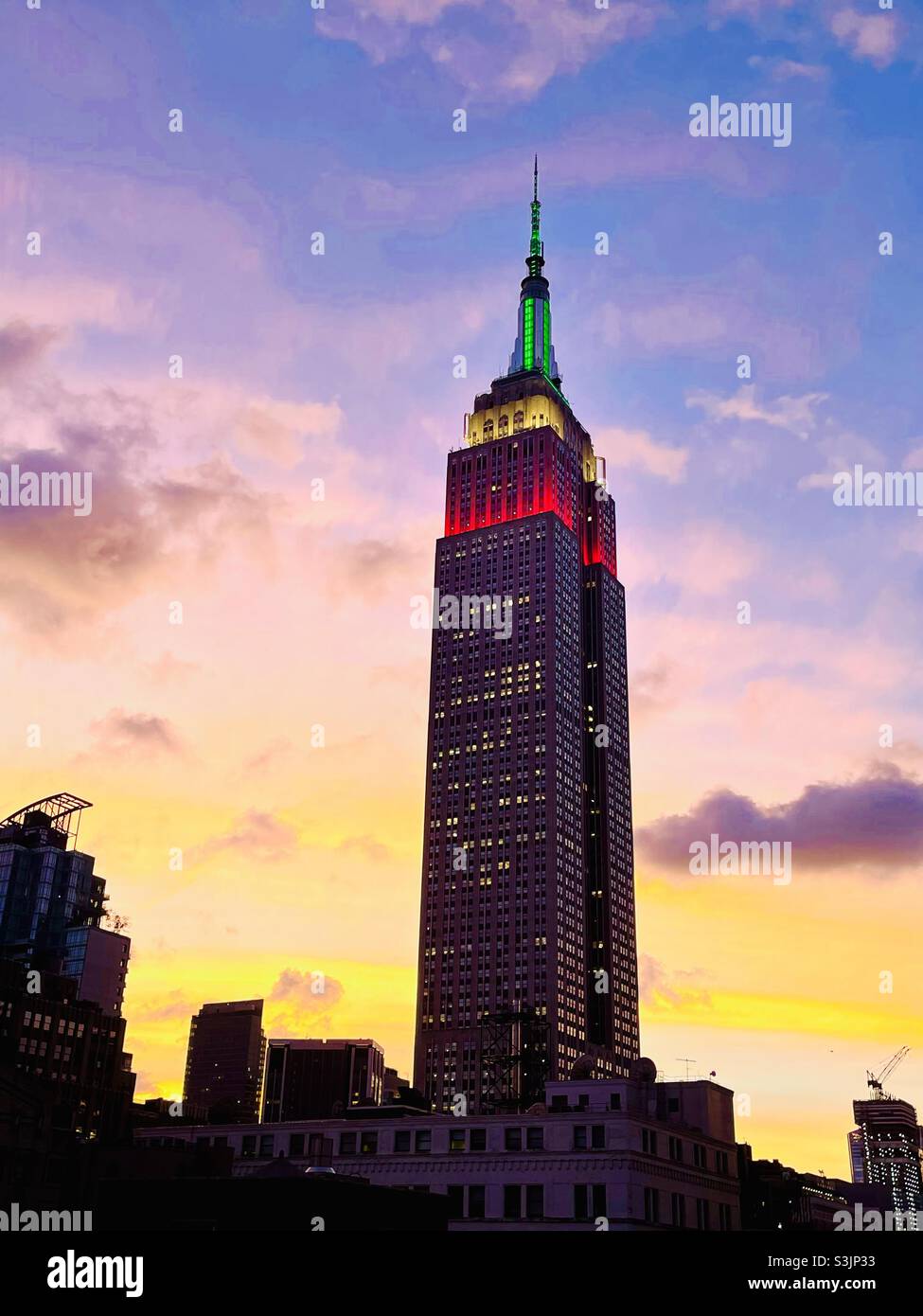Tower lights on Empire State Building glow red, white & green in honor of Italian Heritage Day, Indigenous People Day, Columbus Day October 11, 2021 - Smartphone Captured Stock Image