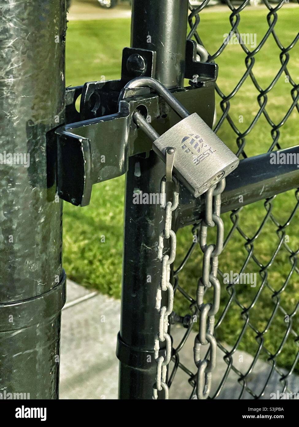 Keyed padlock securing property on a chain link fence - Smartphone Captured Stock Image