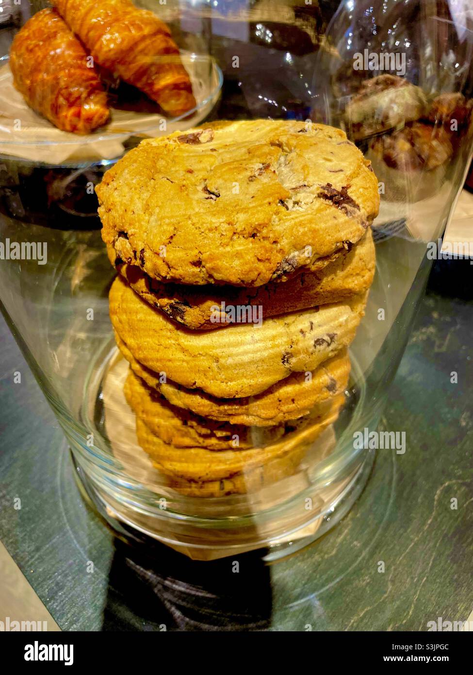 A stack of golden chocolate chip cookies in a glass jar - Smartphone Captured Stock Image