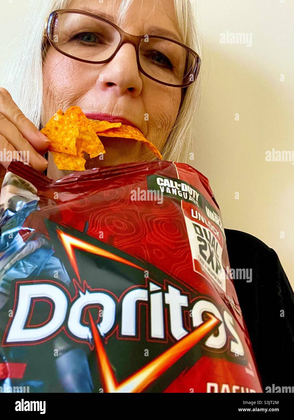 Woman Eating Doritos nacho cheese chips - Smartphone Captured Stock Image