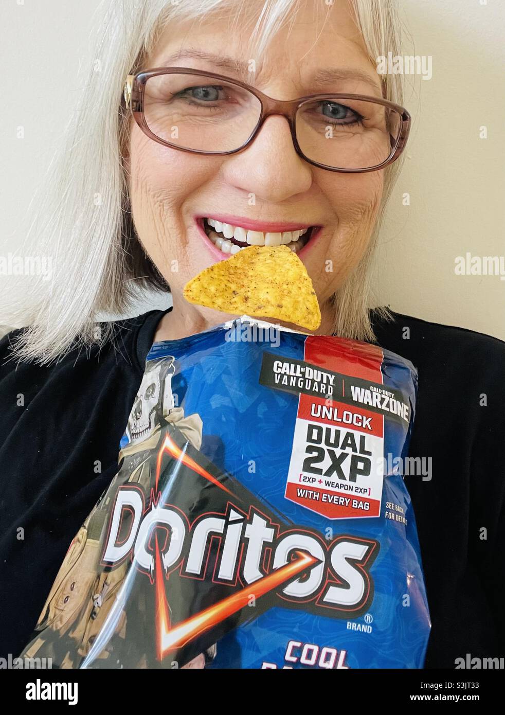 Woman with a big smile eating Doritos - Smartphone Captured Stock Image