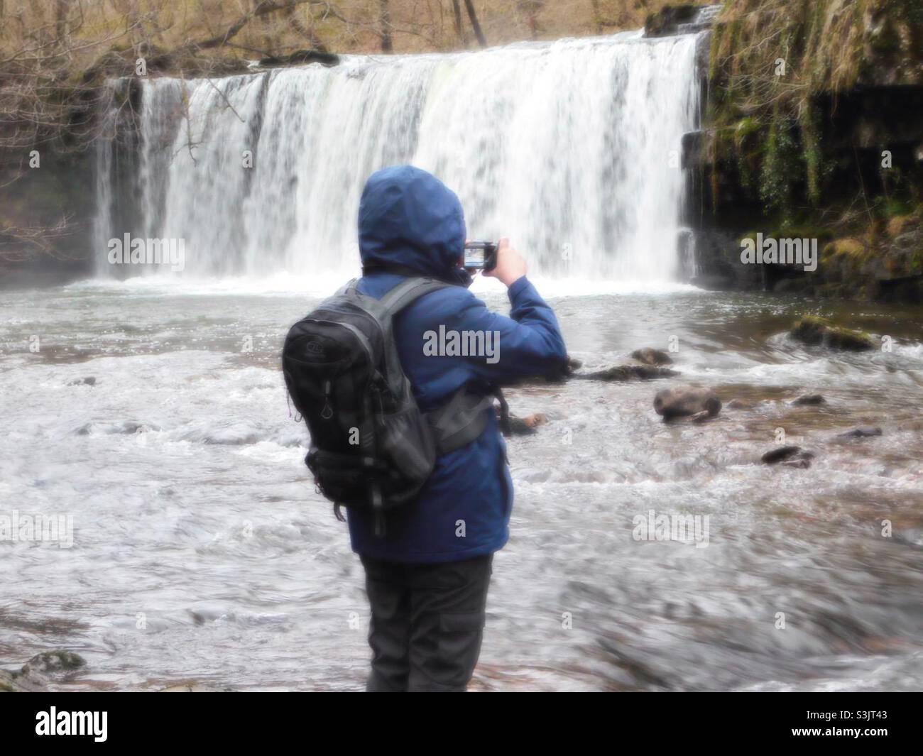 Man taking photo of waterfalls - Smartphone Captured Stock Image