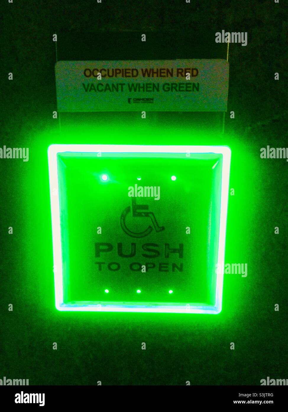 Vacant when green. Push to Open button outside a modern washroom, Ontario, Canada. Wheelchair accessible. Contemporary design. - Smartphone Captured Stock Image