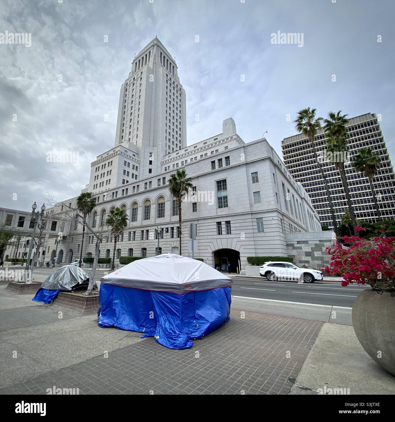 LOS ANGELES, CA, JAN 2021: traffic passing by homeless tents outside City Hall in Civic Center area, Downtown - Smartphone Captured Stock Image