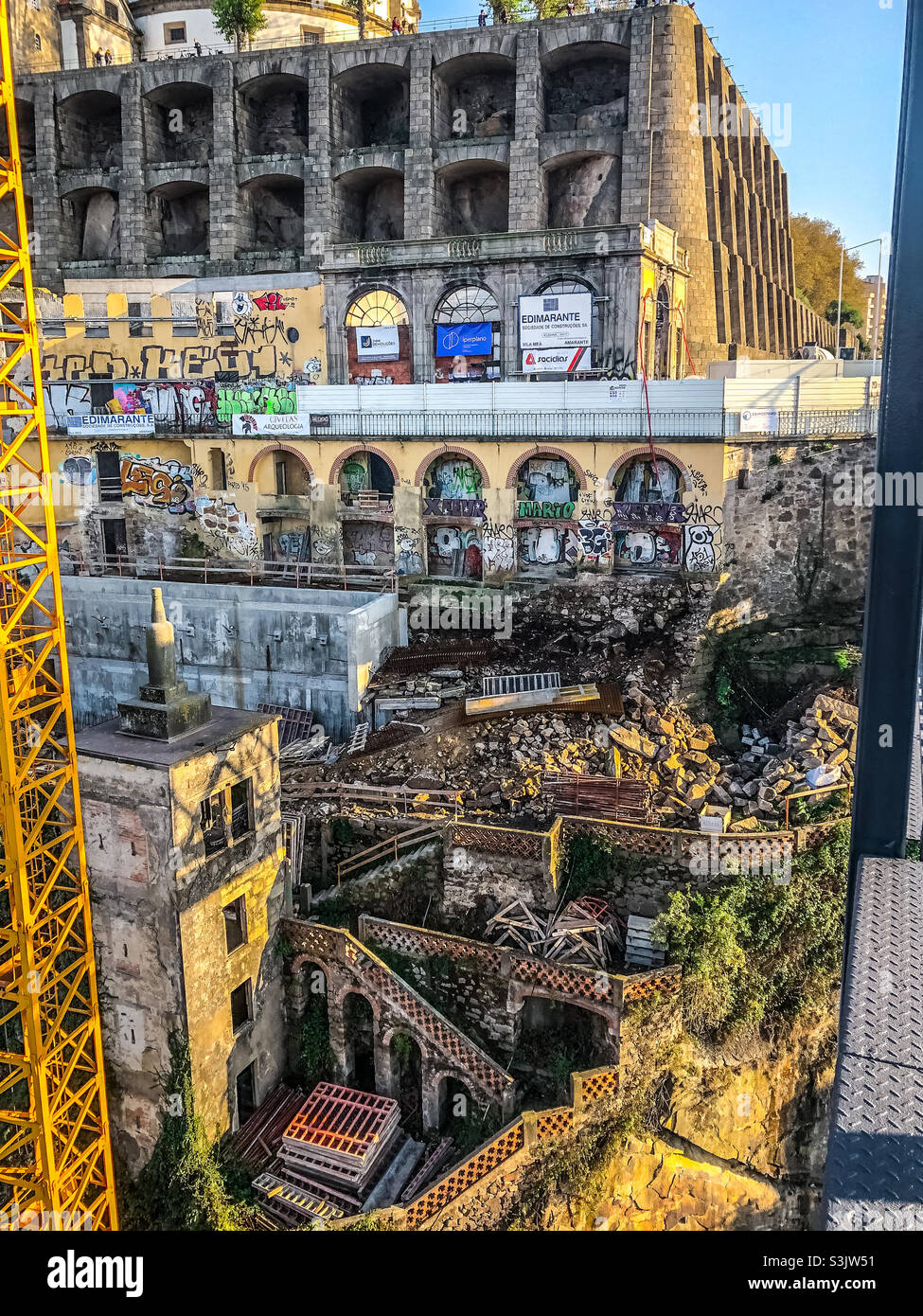 Porto - a view of derelict buildings in the city, framed by the metal structures of a crane a Luís I Bridge - Smartphone Captured Stock Image