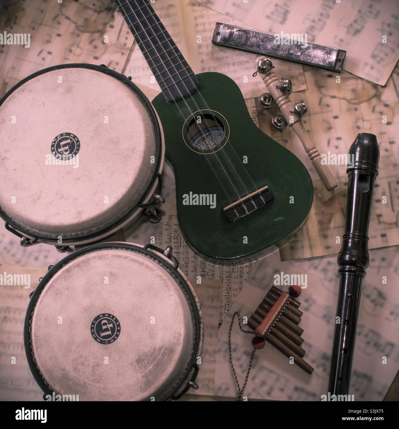 Basic musical instrument themed flat lay on a background of sheet music - Smartphone Captured Stock Image