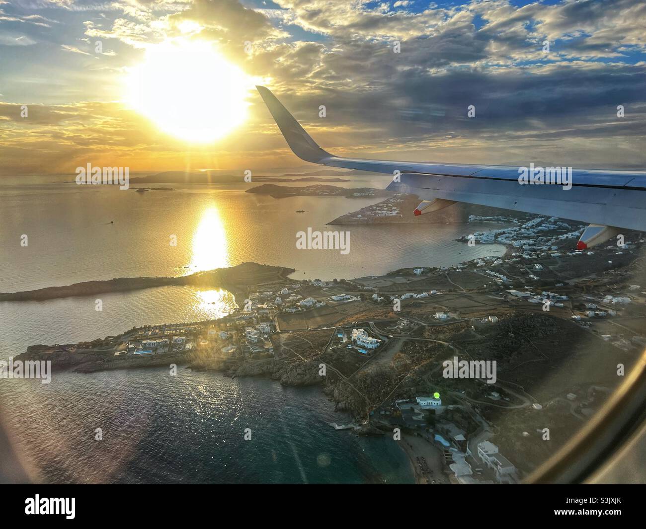 Plane coming into land on Mykonos Island in Greece with the sun setting - Smartphone Captured Stock Image
