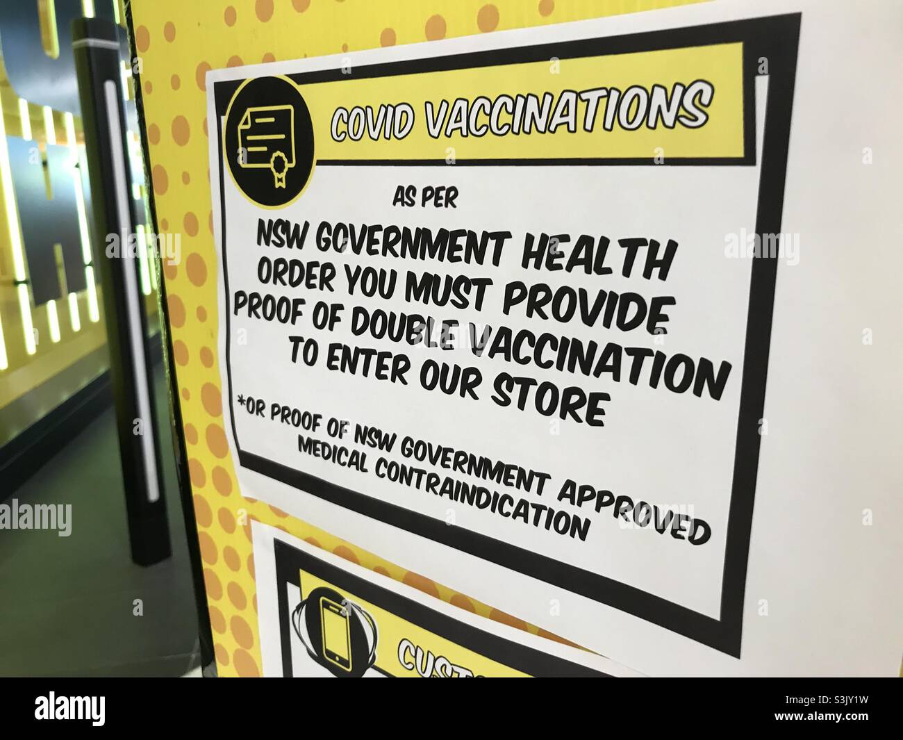 Vaccine passport sign at the entrance to a JB-HiFi electronics store in Sydney, NSW, Australia - Smartphone Captured Stock Image