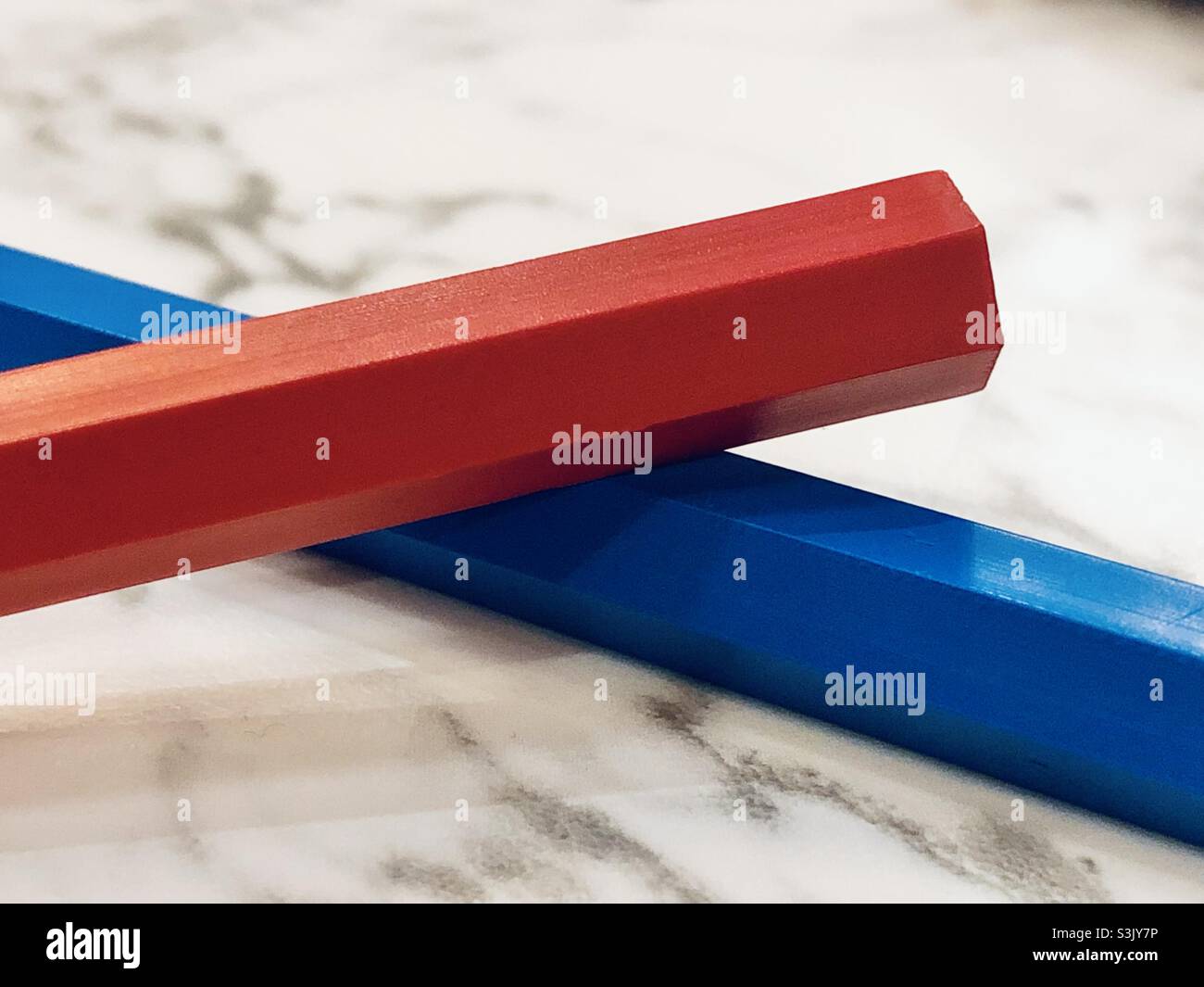 Blue and red crayons on marble table Stock Photo