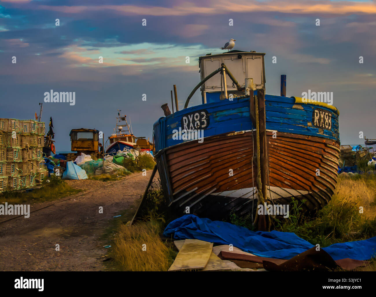 A fishing vessels sits on a working fishing beach in the late afternoon sun - Smartphone Captured Stock Image