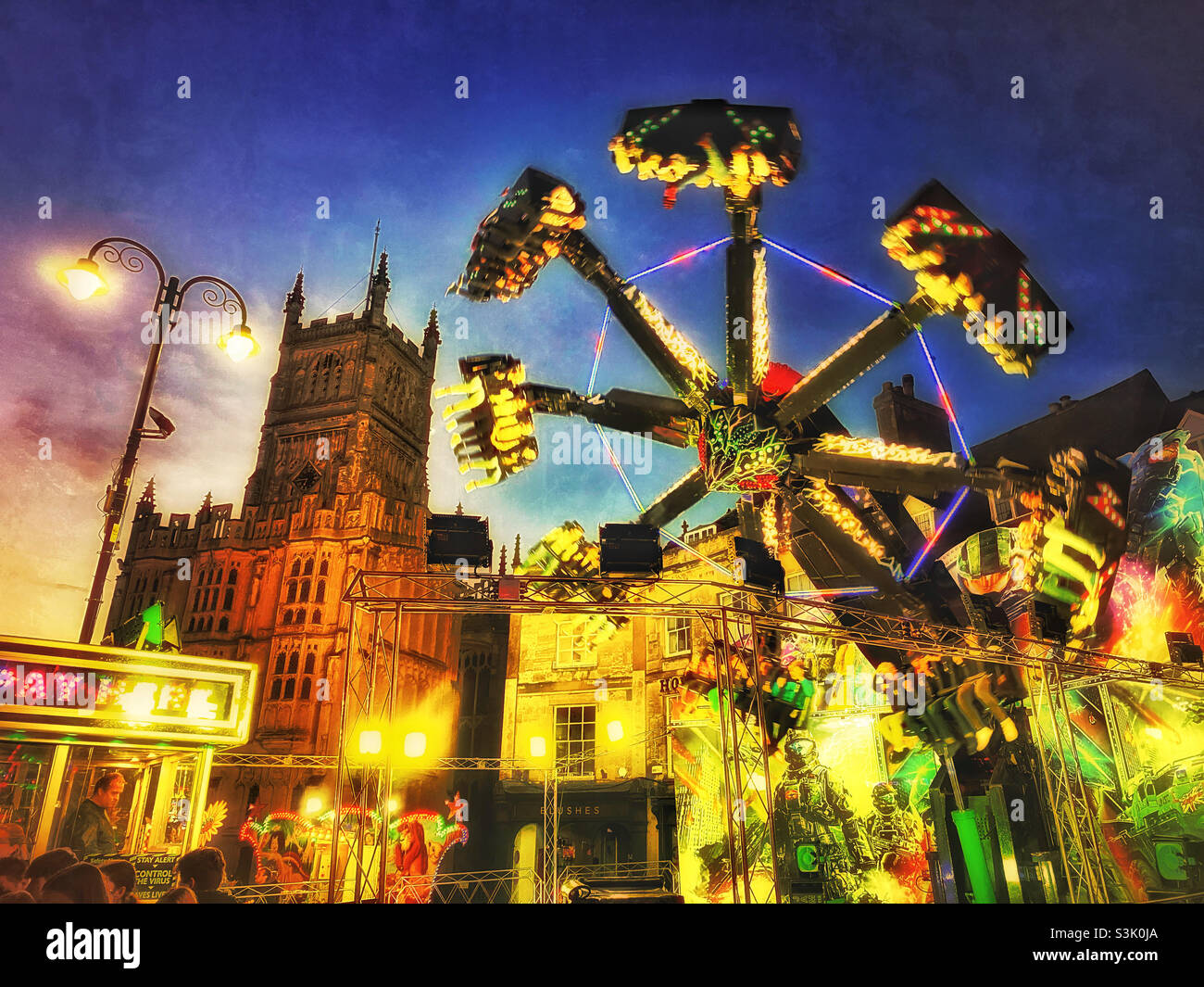 A grunge effect dusk image of a funfair in an English town. Rotating fast on a giant machine is always great fun - right?! Photo ©️ COLIN HOSKINS. - Smartphone Captured Stock Image