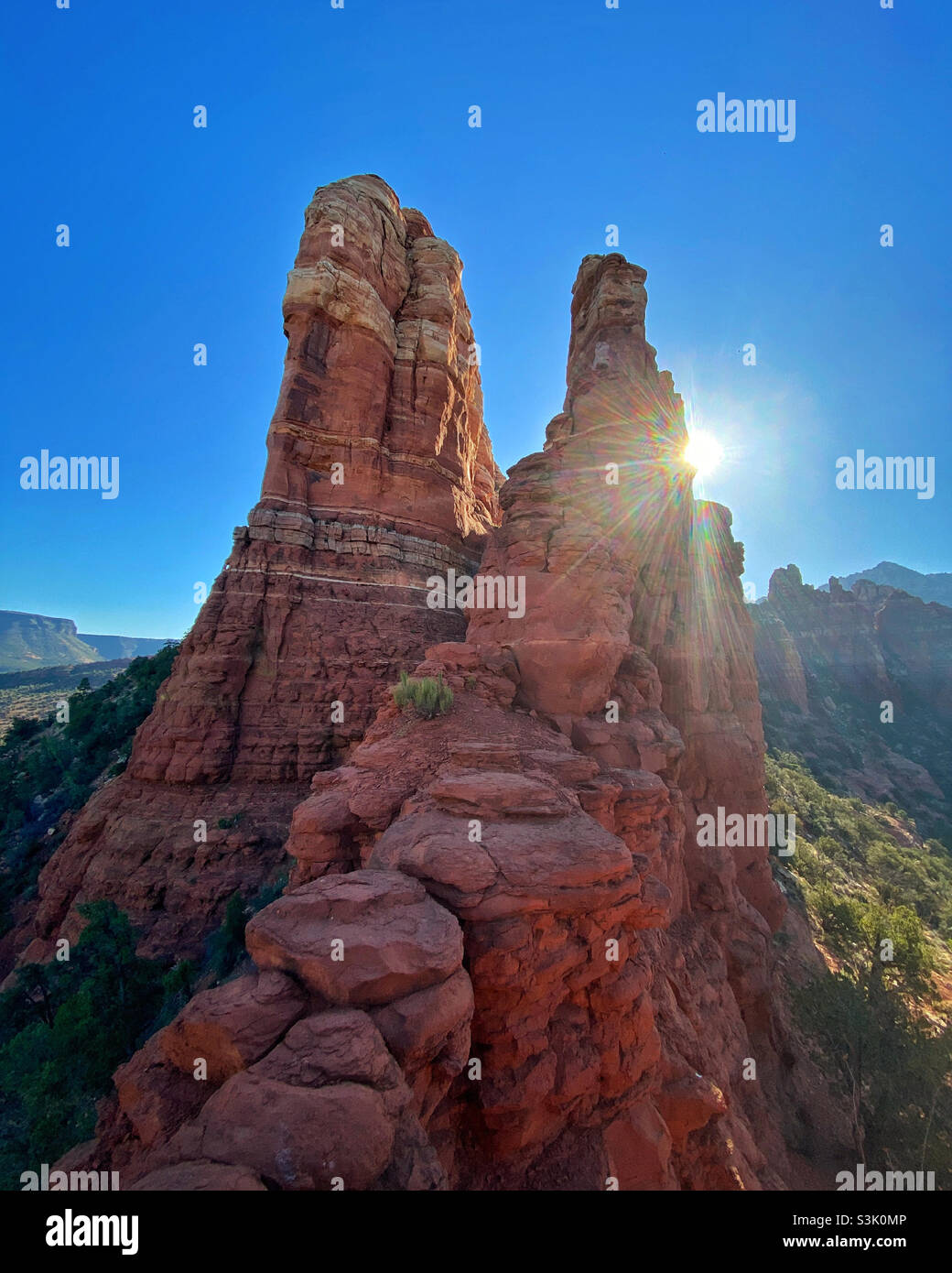 Red rock formation at the top of Snoopy Rock hiking trail in Sedona, Arizona on a sunny morning with a sunburst - Smartphone Captured Stock Image